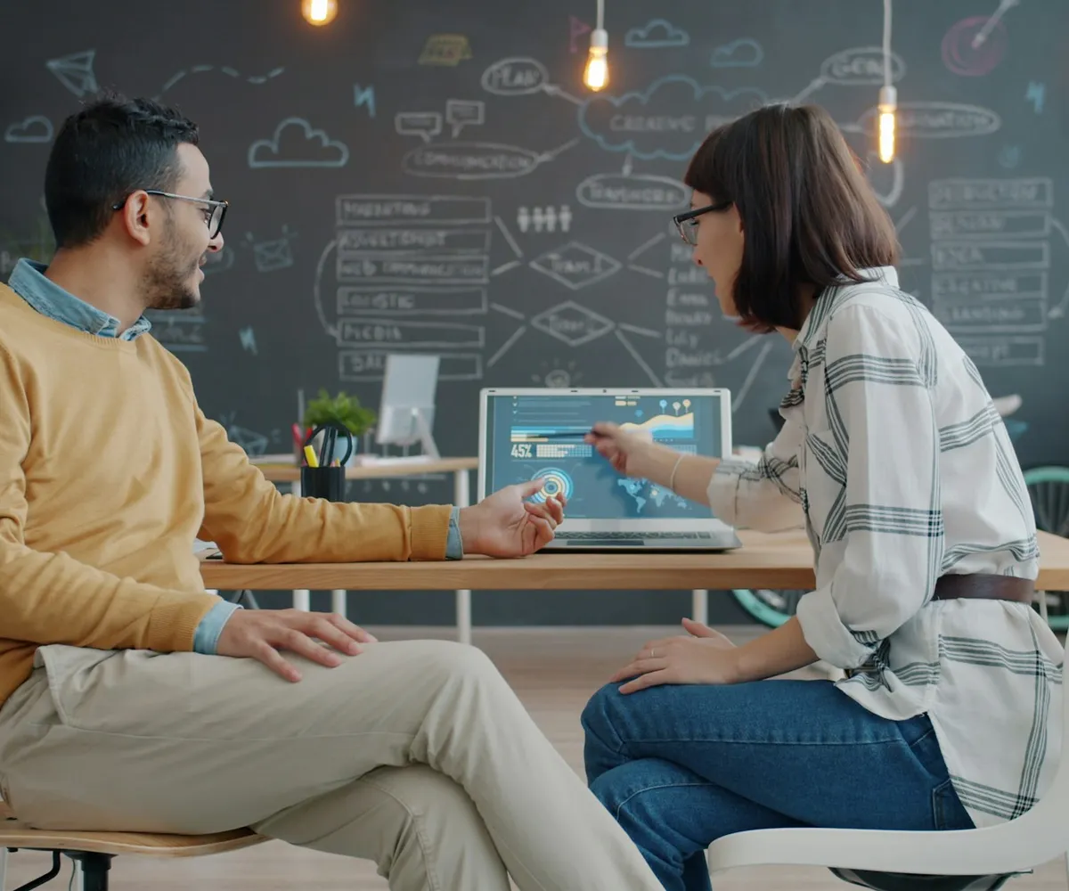 Twee collega’s bespreken een dashboard op een laptop